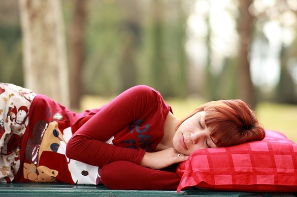 Девушка спит на красной подушке