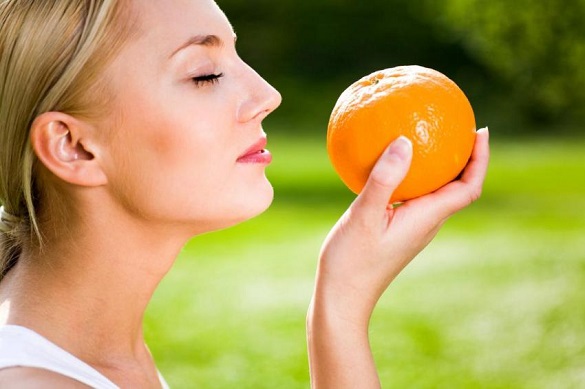 девушка нюхает апельсин