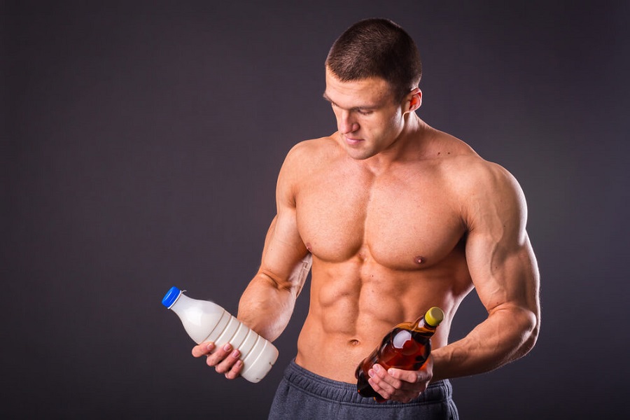Мужчина с голым торсом, держит в руках молоко и пиво